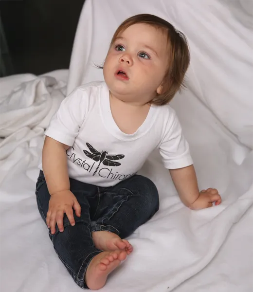 A baby wearing a Crystal Chiropractic t-shirt